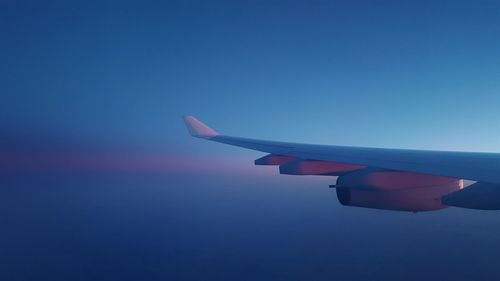 Close-up of airplane wing against clear blue sky