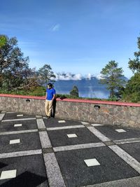 Man standing against lake and sky