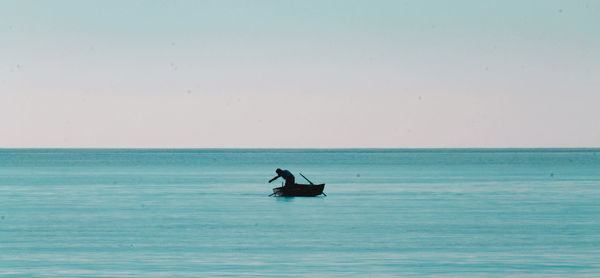 Silhouette man in sea against clear sky