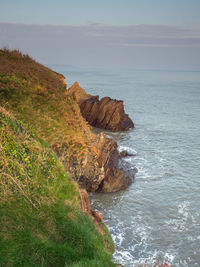 Rock formations in sea against sky