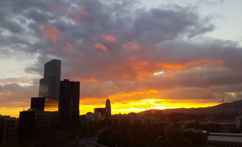 View of cityscape against cloudy sky during sunset