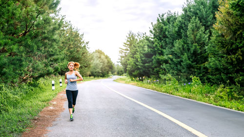 Full length of young woman standing on road