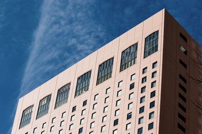 Low angle view of modern building against blue sky