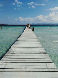 Rear view of pier over sea against sky