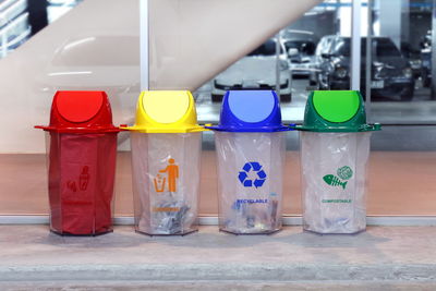 Multi colored recycling bins on sidewalk