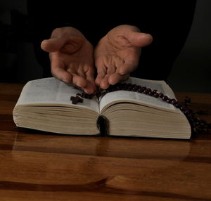 Cropped hand of man holding book