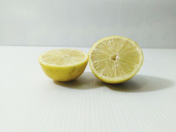 Close-up of oranges on table against white background