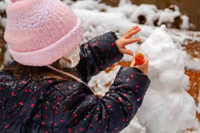 Portrait of girl making a snowman 