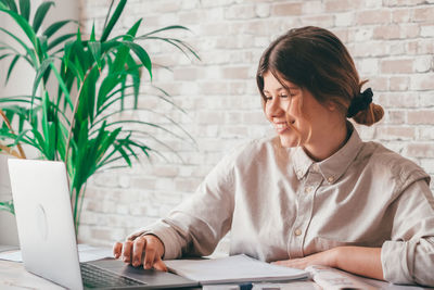 Businesswoman using laptop while sitting on table
