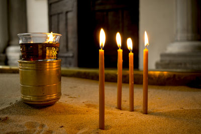 Close-up of illuminated candles in building