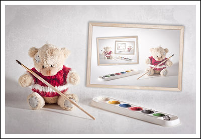 Pallet by teddy bear by picture frame against white background