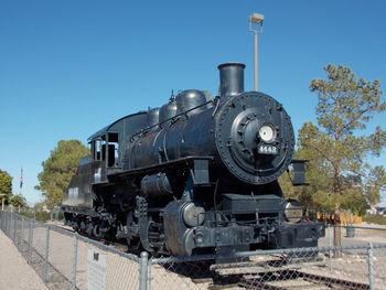 Train on railroad track against clear blue sky