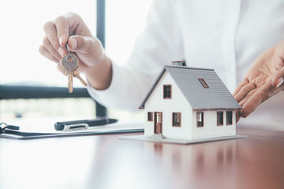 Midsection of man holding umbrella on table in building