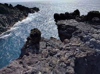 Rock formation in sea against sky