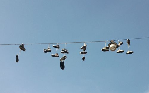 Low angle view of birds flying against clear sky