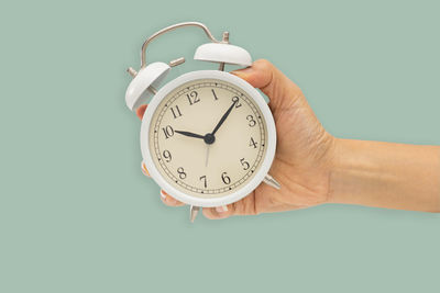 Close-up of hand holding clock