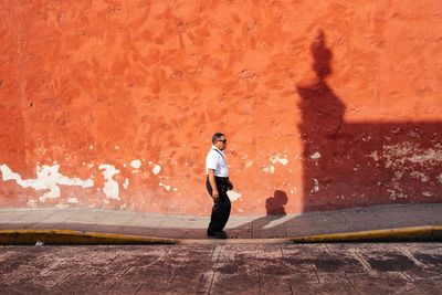 Full length of man walking against wall