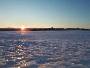 Scenic view of frozen sea against clear sky during sunset