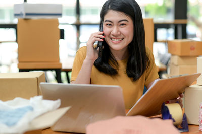 Portrait of smiling woman using mobile phone