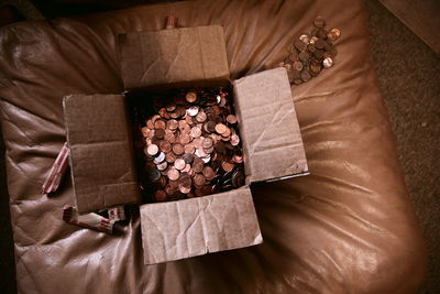 High angle view of us coins in box on ottoman at home