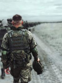 Rear view of military officer walking on field