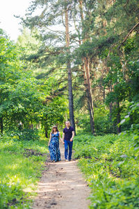 Rear view of people walking in forest