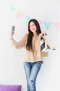 Portrait of smiling young woman using mobile phone