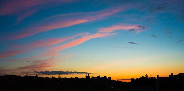 Silhouette buildings against sky during sunset