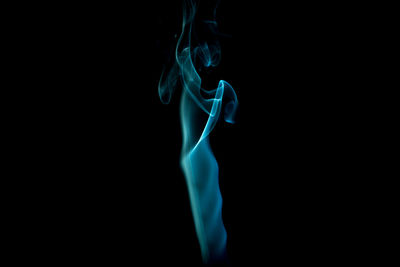 Blue smoke against black background