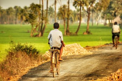 Rear view of boy riding bike