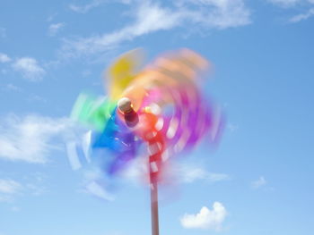 Blurred motion of colorful pinwheel against sky