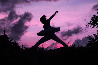 Silhouette teenage girl dancing ballet on field against sky