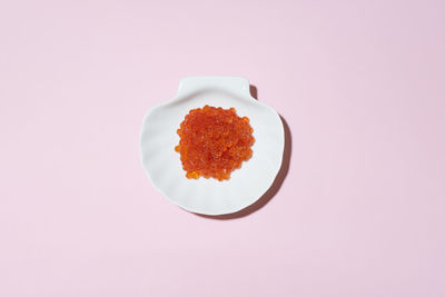 High angle view of caviar in plate against pink background