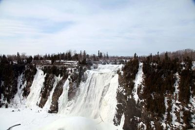 Low angle view of frozen waterfalls against sky