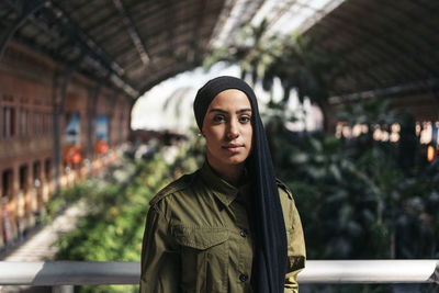 Portrait of young woman standing in city