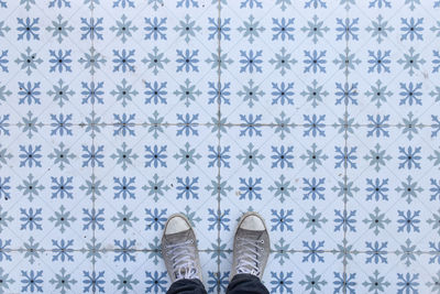 Low section of person standing on tiled floor