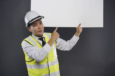 Man working with arms outstretched against gray background