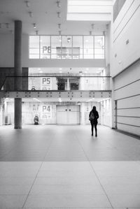 Rear view of woman walking in corridor