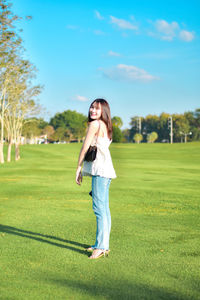 Full length of young woman standing on field