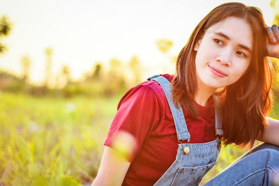 Close-up of young woman sitting on field