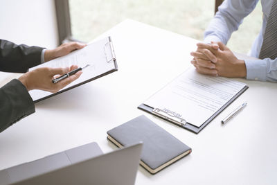 High angle view of people in pen on table