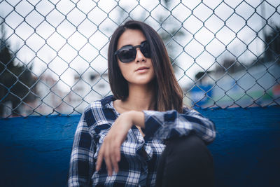 Portrait of young woman wearing sunglasses standing outdoors