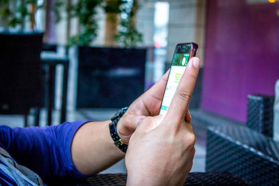 Cropped hands of man using phone at table