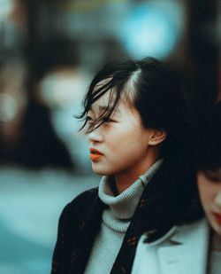 Close-up portrait of young woman looking away