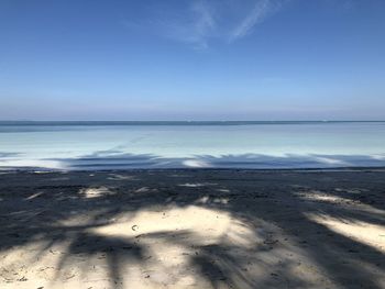 Scenic view of beach against blue sky