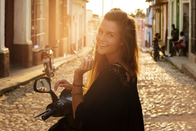 Portrait of young woman standing in city