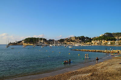 People on beach against clear sky