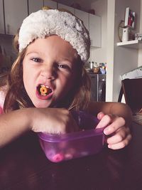 Portrait of cute girl eating snacks at home