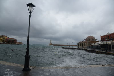 Street by sea against sky in city