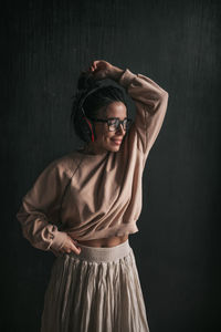 Young woman wearing mask against black background